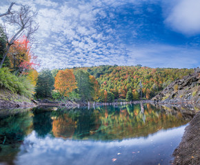 Arcoiris Lagoon at Autumn Season a colorful mirror and sunken trees below the waters make it a dramatic landscape remembering the last eruptions from the near Llaima Volcano, Conguillio National Park
