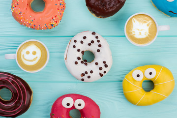 Two cups of coffee and multicolored donuts. Morning coffee with yummy cakes.