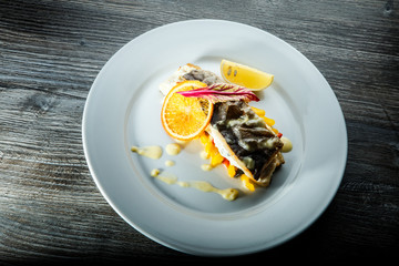 top view of fried white sea fish on pickled pepper garnish