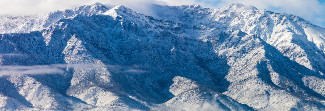 Cerro Ramon and Cerro La Cruz summits during a winter day. Snowcapped summits at central Andes mountains and amazing snowy rugged landscape on a cloudy day, an awe outdoor winter background scenery
