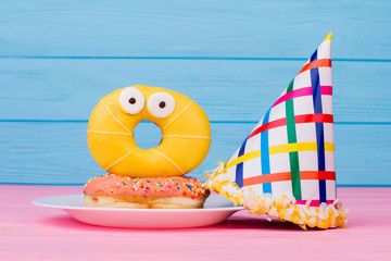 Composition with donuts and kids Birhday hat. Funny yellow donut and cone party cap. Happy Birthday...