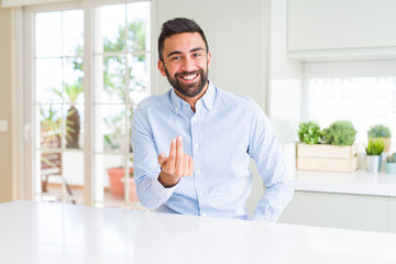 Fototapeta premium Handsome hispanic business man Beckoning come here gesture with hand inviting happy and smiling