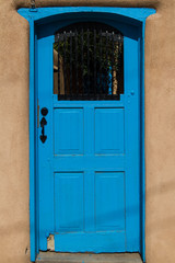 A blue door in an adobe house