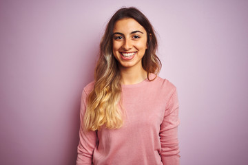 Fototapeta premium Young beautiful woman wearing a sweater over pink isolated background with a happy and cool smile on face. Lucky person.