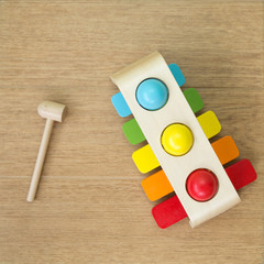 Children's multi-colored wooden xylophone is lying on the floor  Near the hammer. The concept of a naive childhood memory, the end of childhood. Size square. Top view