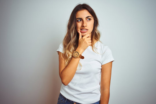 Young beautiful woman wearing casual white t-shirt over isolated background Thinking worried about a question, concerned and nervous with hand on chin