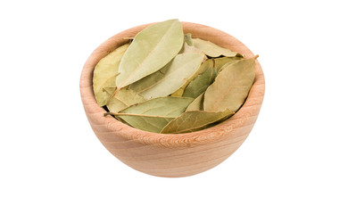 bay leaves in wooden bowl isolated on white background. 45 degree view. Spices and food ingredients.