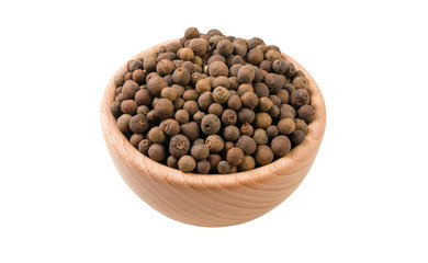 allspice or Jamaican pepper in wooden bowl isolated on white background. 45 degree view. Spices and food ingredients.