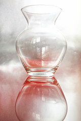 Transparent glass jug on a silver pink background. An example for a sketch on a drawing lesson at an art school
