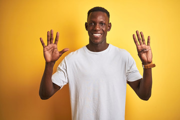 Young african american man wearing white t-shirt standing over isolated yellow background showing...