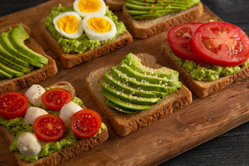 Six Varieties of Avocado Toast on a Wooden Table