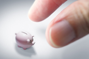 Inflation vs Savings, illustrated by tiny piggy bank (diminishing value of savings) compared to fingers.