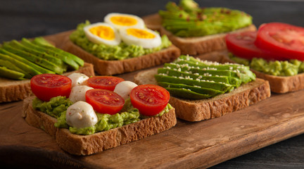 Six Varieties of Avocado Toast on a Wooden Table