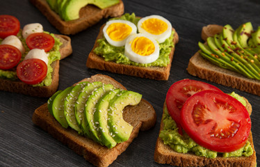 Six Varieties of Avocado Toast on a Wooden Table