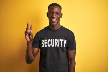 African american safeguard man wearing security uniform over isolated yellow background showing and...