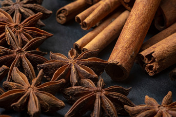 Brown star anise and cinnamon on a dark background