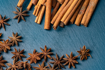 Brown star anise and cinnamon on a dark background