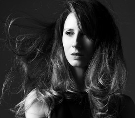 Black and white fashion art studio portrait of beautiful elegant woman with windy hair 