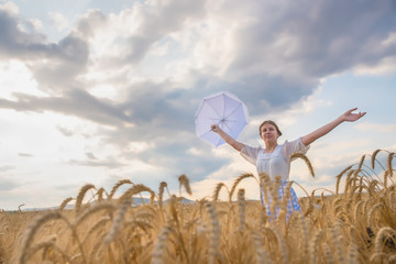 Naklejka na ściany i meble Girl in a field of wheat