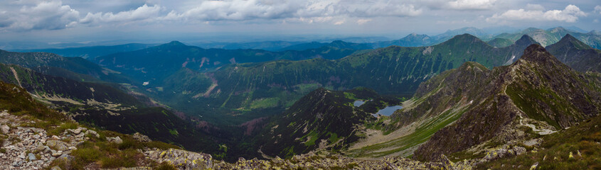 Panoramic view from Banikov peak on Western Tatra mountains or Rohace panorama. Sharp green mountains - ostry rohac, placlive and volovec with hiking trail on ridge. Summer blue sky white clouds. - obrazy, fototapety, plakaty