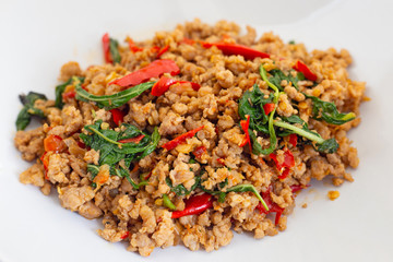 Stir-fried hot and spicy pork with basil on white.