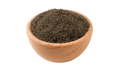 ground or milled nigella in wooden bowl isolated on white background. 45 degree view. Spices and food ingredients.