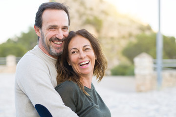 Romantic couple smiling,  cuddling and hugging on a sunny day