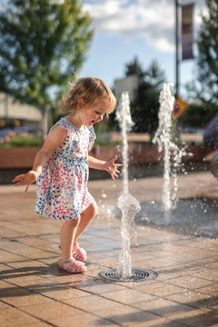 Cute Little Girl Playing Happy at City Fountain