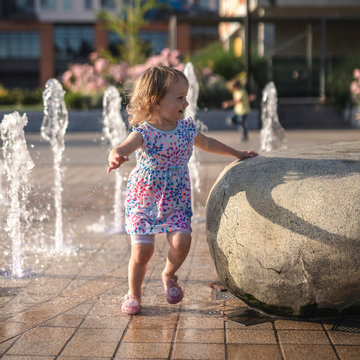 Little Girl Smiling Running Around City Fountain