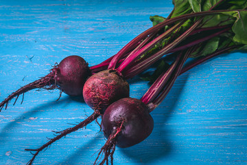 A bunch of fresh beets on old blue wooden table. Copy space. Healthy food. Raw Vegetables.