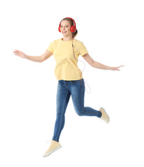 Jumping young woman listening to music on white background