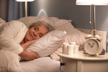 Senior woman sleeping in bed at night