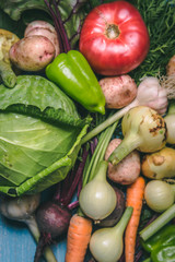 Tomato, cabbage, onion, potato, pepper, garlic, carrot and beetroot. Vegetables in a basket on a blue background. Copy space. Healthy food.