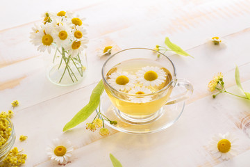 Cup of hot chamomile tea on wooden table