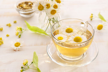 Cup of hot chamomile tea on wooden table