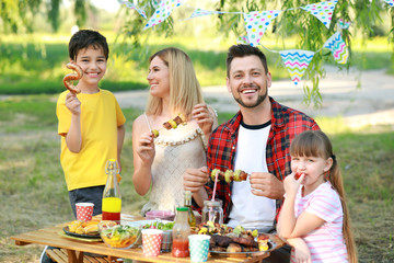 Happy family having picnic on summer day