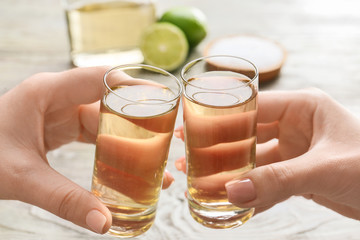 Women drinking tequila at table, closeup
