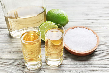 Shots of tequila on wooden background