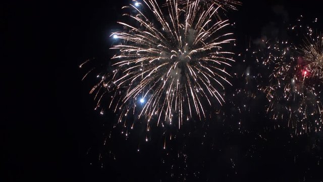 Colorful fireworks exploding in the night sky in busts of red, white and blue bringing joy