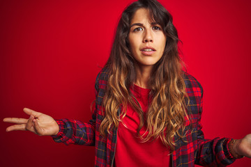 Young beautiful woman wearing casual jacket standing over red isolated background stretching back, tired and relaxed, sleepy and yawning for early morning