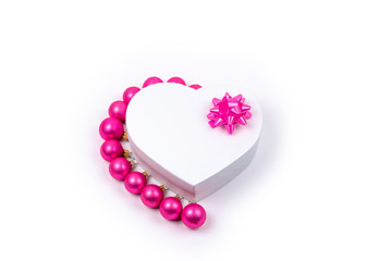 Heart shaped Christmas gift box, Christmas balls with pink bow for holiday, christmas, thanks giving day, birthday top view isolated on white background. 
