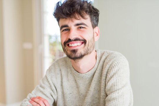 Handsome young man smiling cheerful at the camera with a big smile on face showing teeth