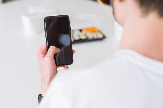 Close upf man using smartphone to orden take away asian food from delivery