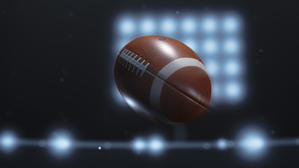 Closeup of a football flying through the air in a lit stadium at night