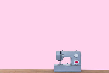 Minimal style Sewing machine on wooden table in tailor's workshop