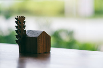 a small wooden house and tree model on the table