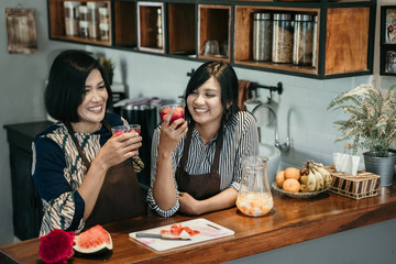 Woman make sweet drink from fruits in the kitchen at home