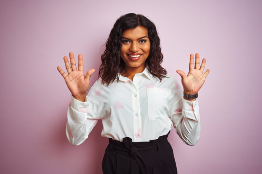 Transsexual transgender businesswoman standing over isolated pink background showing and pointing up with fingers number ten while smiling confident and happy.