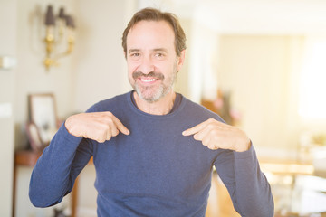 Handsome middle age man at home looking confident with smile on face, pointing oneself with fingers proud and happy.