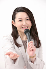 マイクを持って話すビジネスウーマン